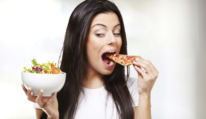 Woman eating pizza instead of salad