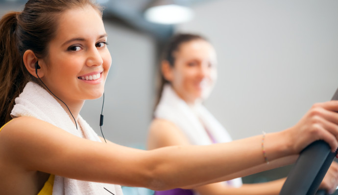 Woman on treadmill with earphones and towel